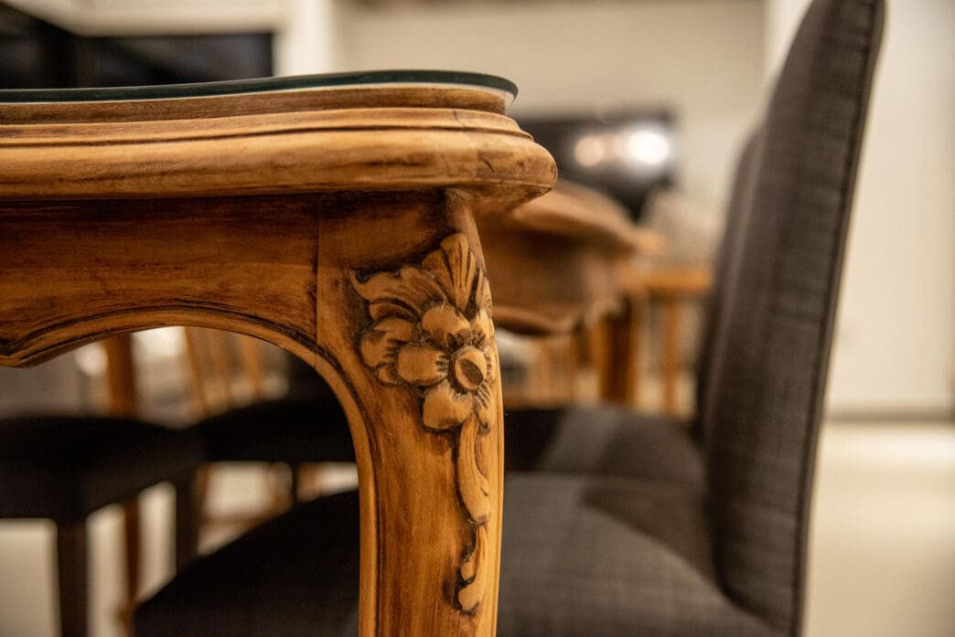 Detailed close-up of ornate wooden table leg with carved floral design