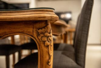 Detailed close-up of ornate wooden table leg with carved floral design