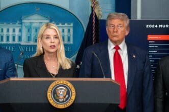 Attorney General Pam Bondi speaks at a press conference with President Donald Trump looking on