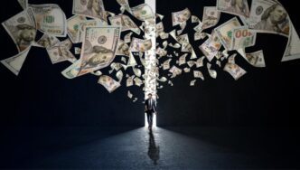 A businessman walks through a glowing doorway with one hundred dollar bills flying around him