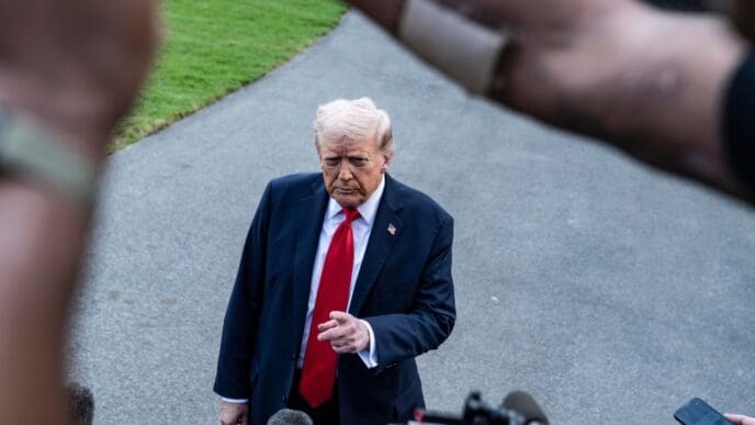 Donald Trump speaks to journalists from an elevated position with a serious expression