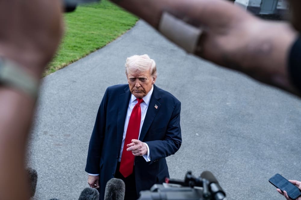 Donald Trump speaks to journalists from an elevated position with a serious expression