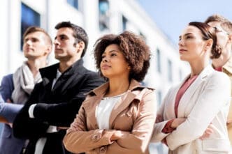 A diverse group of professionals with arms crossed, looking forward