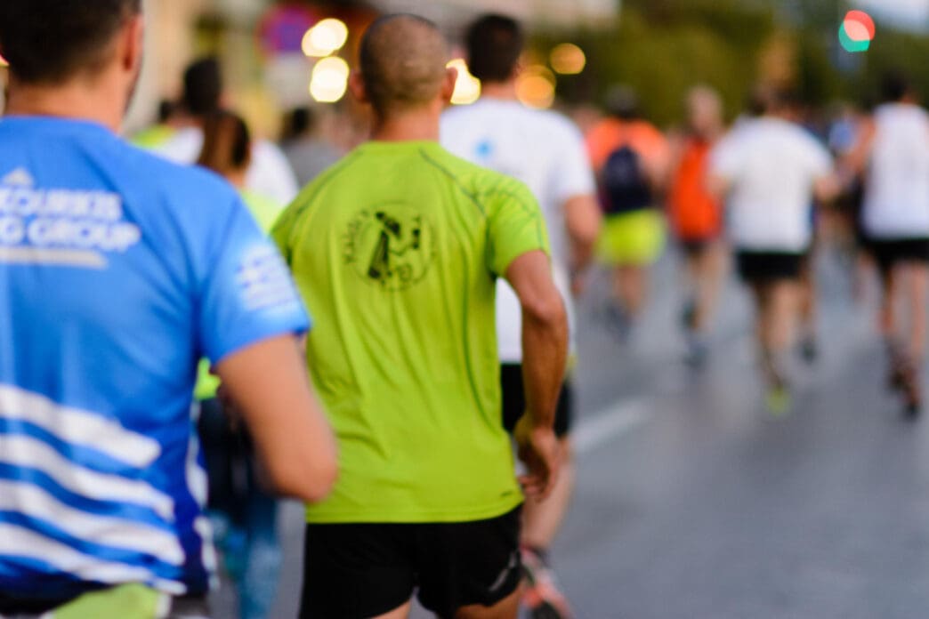 A group of people runs down a street together as part of a running club