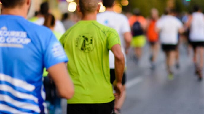 A group of people runs down a street together as part of a running club