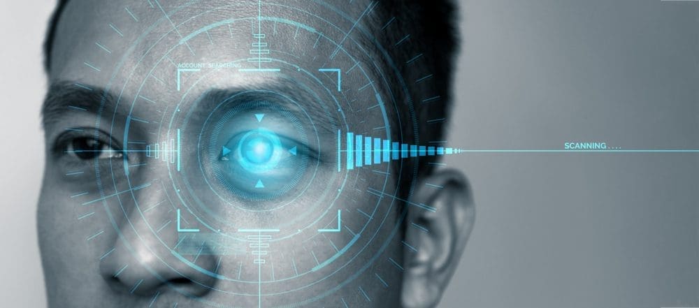 A person's eye being scanned with a digital, futuristic blue interface overlay