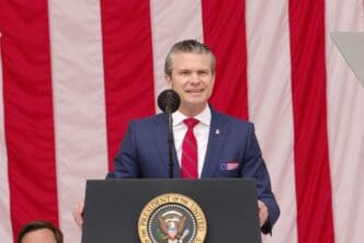 Secretary of Defense Peter Hegseth speaks at a podium with the Presidential Seal