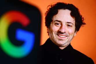 Sergey Brin, co-founder of Google, smiles next to a blurred Google logo