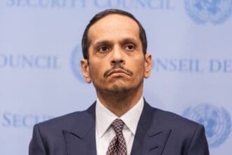 A portrait of Sheikh Mohammed bin Abdulrahman Al-Thani, Prime Minister of Qatar, with a serious expression