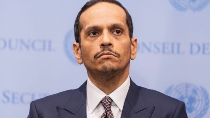 A portrait of Sheikh Mohammed bin Abdulrahman Al-Thani, Prime Minister of Qatar, with a serious expression