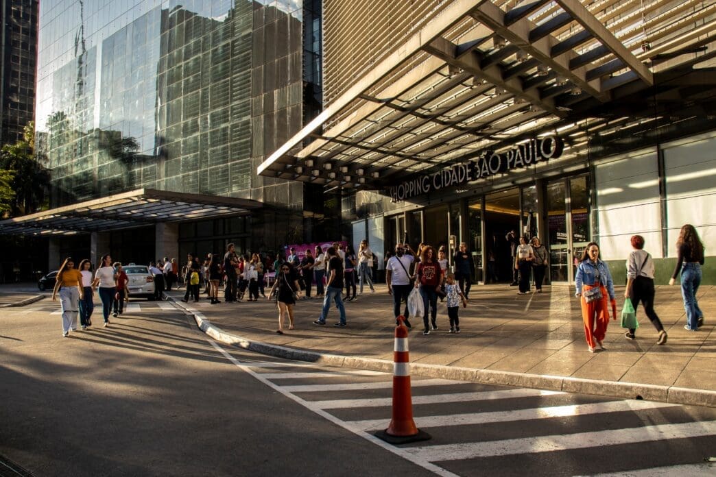Shoppers and traffic near the entrance of Shopping Cidade Sao Paulo on Paulista Avenue