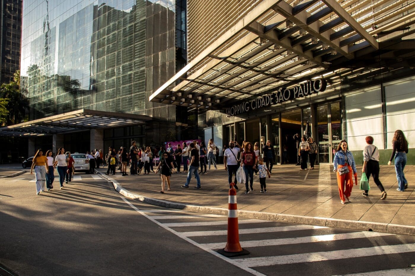 Shoppers and traffic near the entrance of Shopping Cidade Sao Paulo on Paulista Avenue