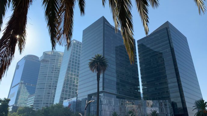 Iconic skyscrapers on Paseo de la Reforma in Mexico City, with palm fronds in the foreground