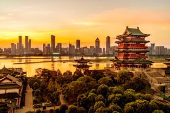 The Pavilion of Prince Teng and modern skyscrapers on the banks of a river at sunset
