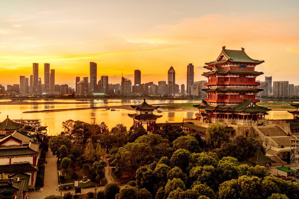 The Pavilion of Prince Teng and modern skyscrapers on the banks of a river at sunset