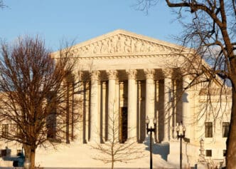 The Supreme Court building with bare trees in the foreground