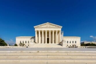 The majestic white marble Supreme Court building with its grand columns on a sunny day