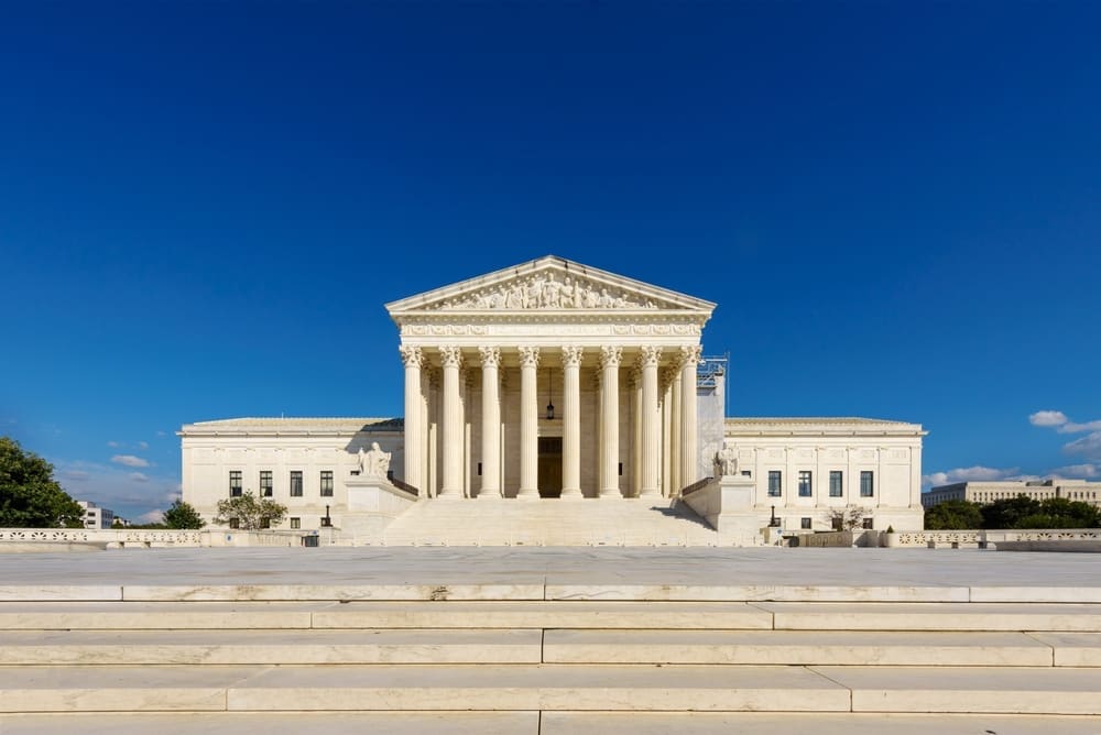 The majestic white marble Supreme Court building with its grand columns on a sunny day