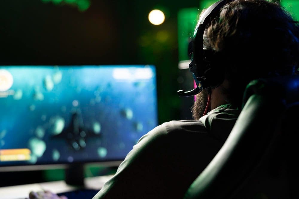 An esports player wearing a headset, looking at a computer screen during a video game
