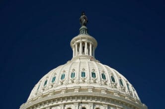 Close-up of the dome of the U.S. Capitol building against a clear blue sky