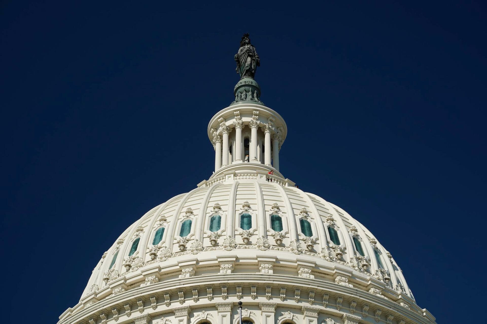 Close-up of the dome of the U.S. Capitol building against a clear blue sky