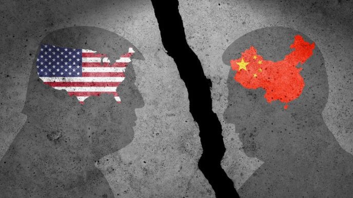 Two head silhouettes face each other across a large crack, with the US and Chinese flags inside them