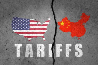A cracked concrete wall with maps of the United States and China on opposite sides and the word "Tariffs" below