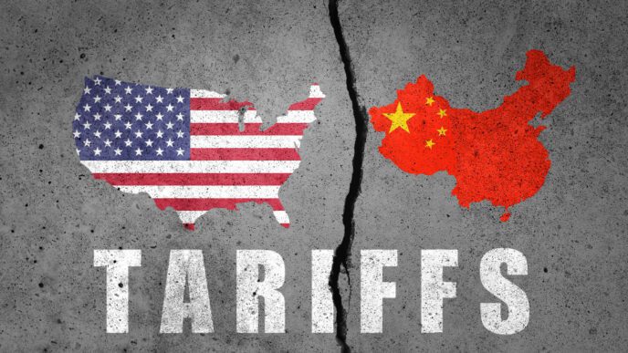 A cracked concrete wall with maps of the United States and China on opposite sides and the word "Tariffs" below