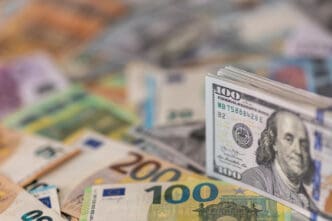 Stack of US hundred dollar bills on top of Euros