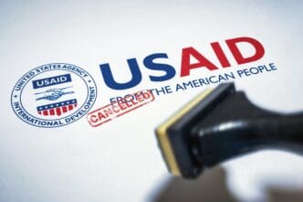 The USAID logo is stamped on a document with a "CANCELLED" stamp over it