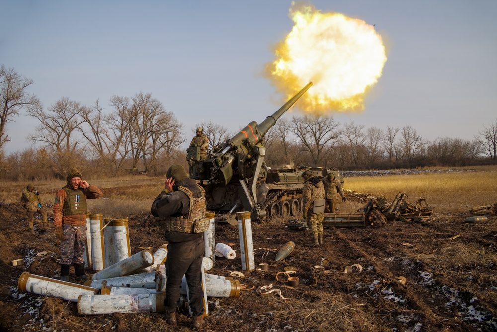 Ukrainian gunners fire a 2S7 Pion artillery cannon, creating a large flash of fire and smoke