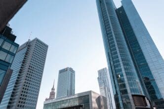 Modern skyscrapers with mirrored glass facades against a clear blue sky in Warsaw