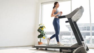 Woman running on a treadmill in a bright room
