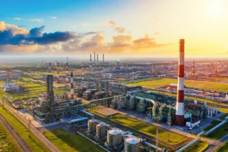 A panoramic aerial view of a sprawling oil refinery complex with many pipes and smokestacks