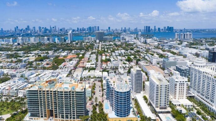 Aerial view of Miami Beach's coastline with skyscrapers and a vibrant cityscape under daylight.