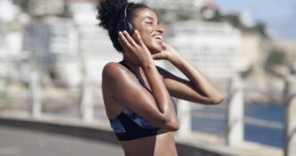 An athlete with headphones listens to music or a podcast while exercising in an urban environment.