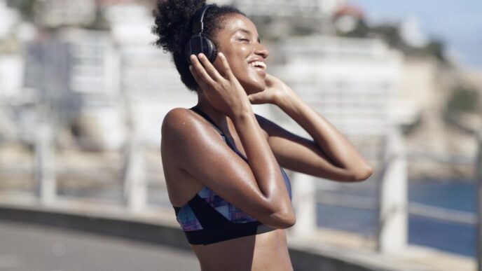 An athlete with headphones listens to music or a podcast while exercising in an urban environment.
