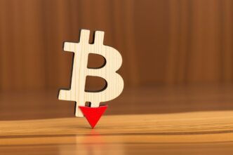 A downward-trending graph depicts the decline in Bitcoin's price, representing a cryptocurrency market downturn.