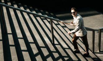 A young businessman climbs a flight of stairs, representing upward mobility.