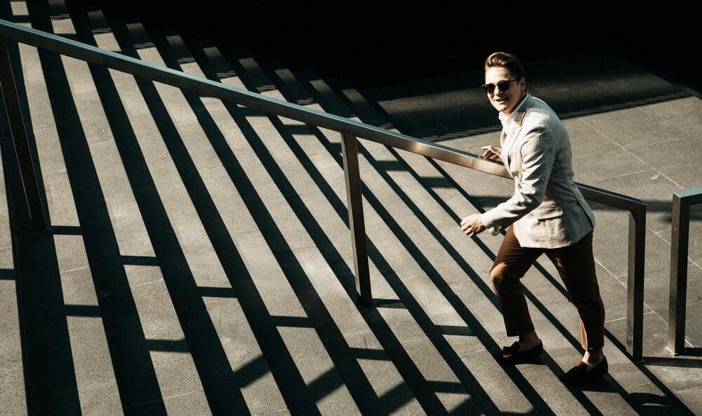 A young businessman climbs a flight of stairs, representing upward mobility.