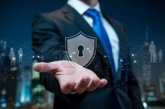 A businessman in a blue suit holds a shield with a keyhole design and network connections superimposed over a city skyline.