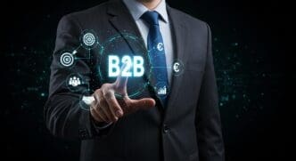A businessman touches a digital interface displaying a business-to-business (B2B) concept.