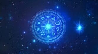 Glowing, colorful cosmic symbol with astrological and celestial themes on a dark background.