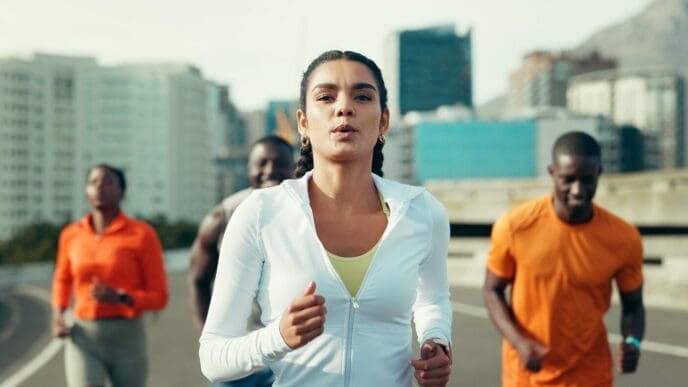 A group of friends runs together through a city, likely training for a marathon or other race.