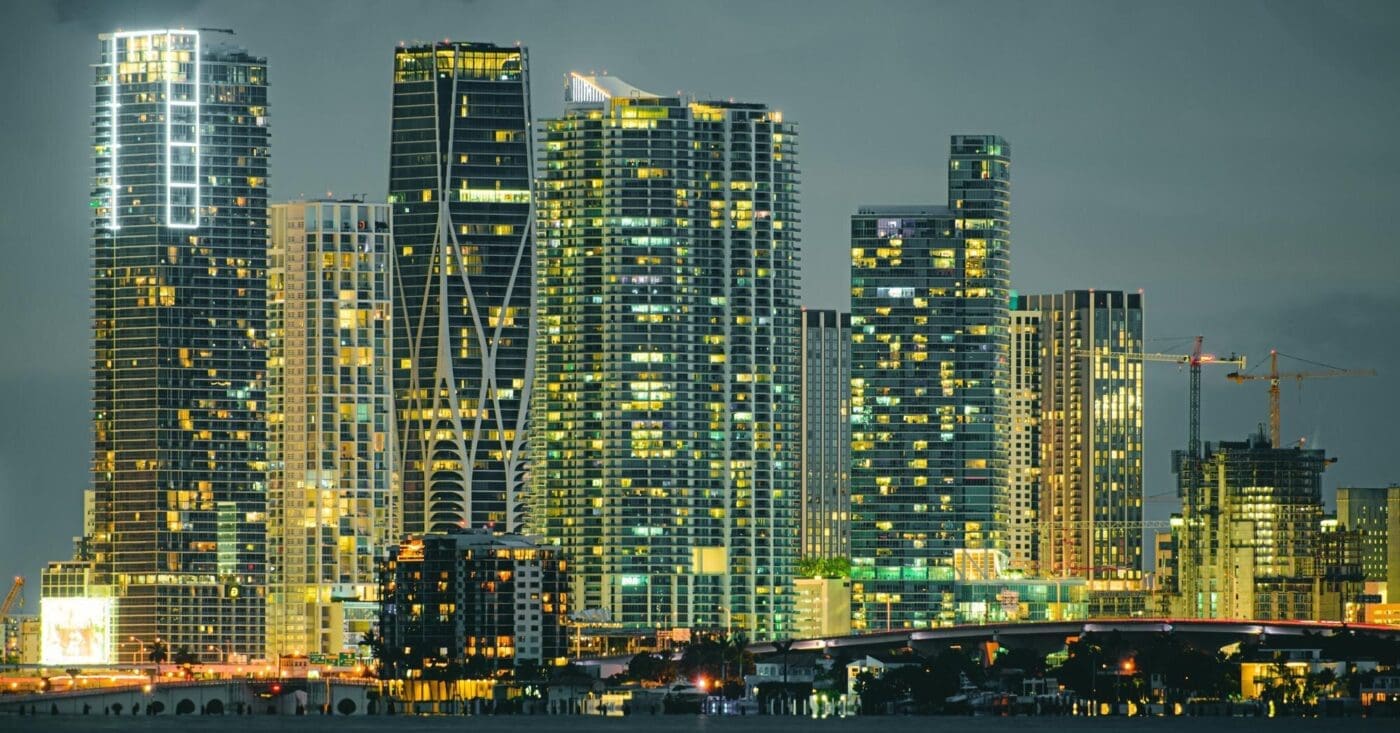 Skyscrapers illuminated at night line the shore of South Beach, Miami.