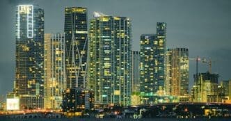 Skyscrapers illuminated at night line the shore of South Beach, Miami.