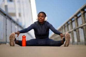 A determined woman athlete in workout gear stretches and prepares for a run.