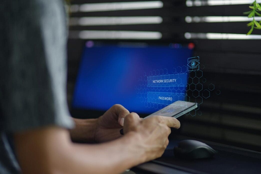 A person uses a smartphone to interact with a network security technology interface.