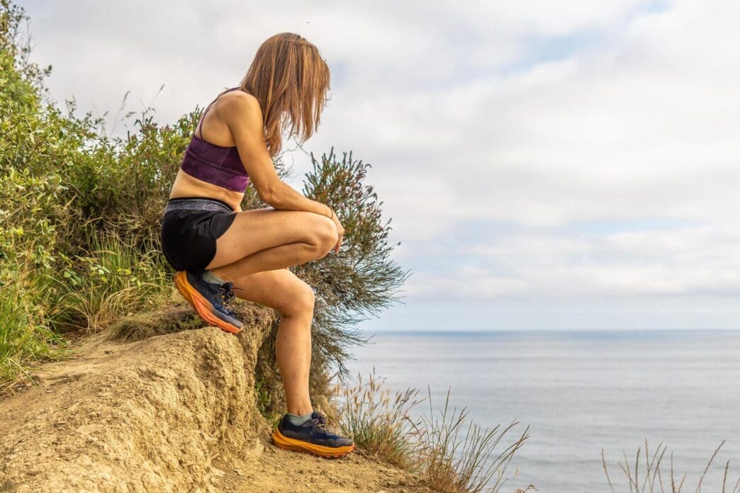 A runner takes a break to enjoy the scenic view of the beach in Zumaia, Basque Country.