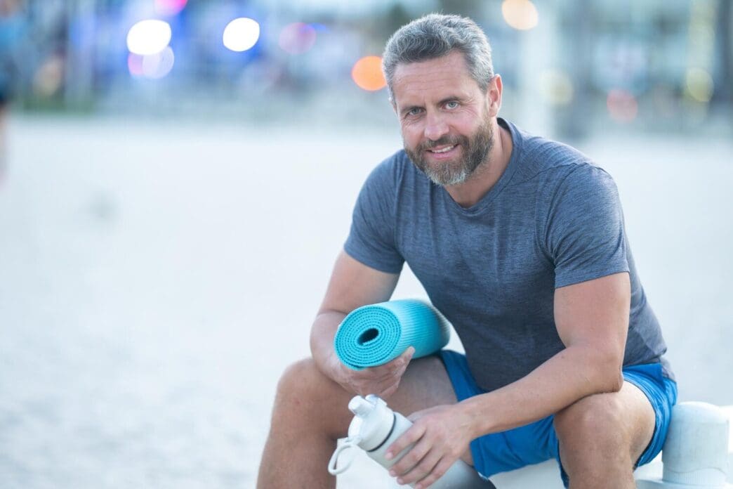 A man rests on a bench, likely outdoors, after a workout.